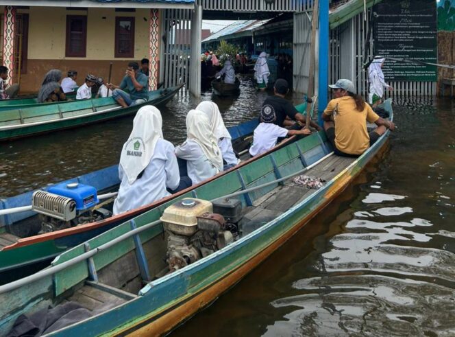 
 Sekolah Tetap Berjalan di Tengah Banjir, Siswa MTsN 7 Banjar Datang Naik Perahu